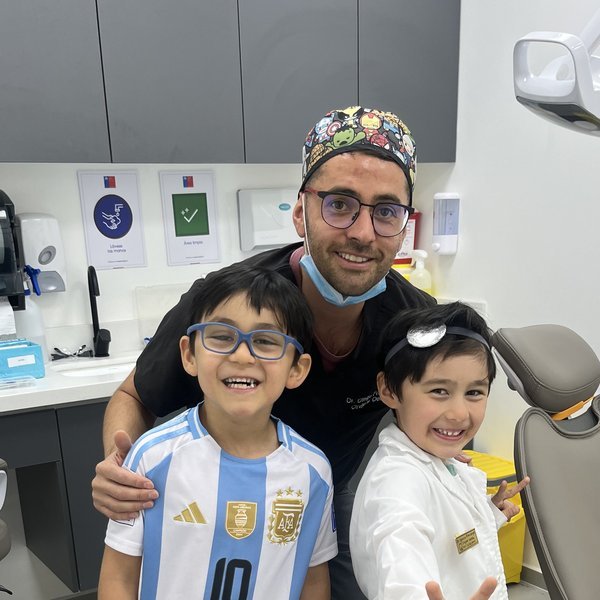 El Dr. Diego Frávega junto a dos pacientes pequeños en la consulta